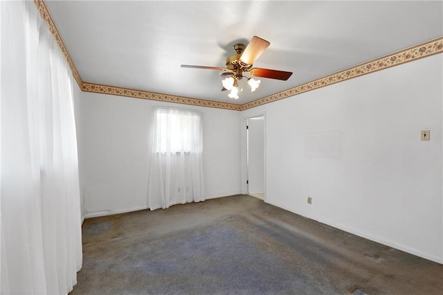 carpeted spare room with ceiling fan and baseboards