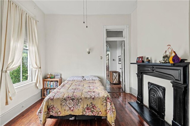 230406 Valmont St, New Orleans, LA 70115 - bedroom featuring wood finished floors, a fireplace with raised hearth, and baseboards