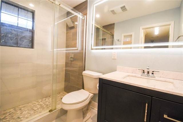 full bathroom featuring toilet, a stall shower, and vanity