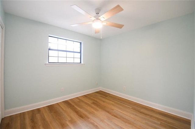 spare room featuring light wood-style floors, baseboards, and ceiling fan