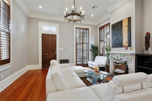 2026 Camp St, New Orleans, LA 70130 - living room featuring a chandelier, healthy amount of natural light, wood finished floors, baseboards, and crown molding