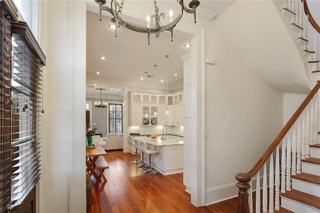 2026 Camp St, New Orleans, LA 70130 - corridor with a chandelier, stairs, dark wood finished floors, ornamental molding, and a sink