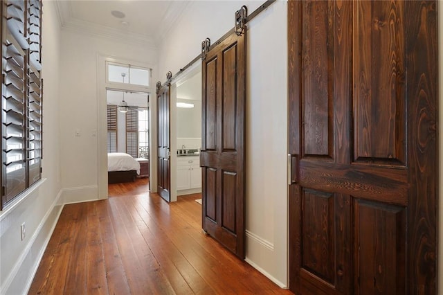 2026 Camp St, New Orleans, LA 70130 - hall with a barn door, hardwood / wood-style floors, baseboards, and crown molding