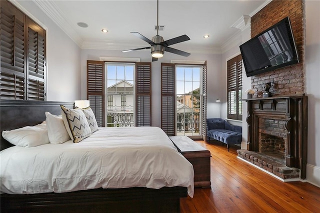 2026 Camp St, New Orleans, LA 70130 - bedroom featuring a stone fireplace, hardwood / wood-style flooring, crown molding, recessed lighting, and baseboards