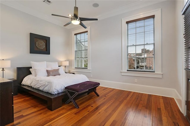 2026 Camp St, New Orleans, LA 70130 - bedroom featuring wood-type flooring, baseboards, crown molding, and a ceiling fan