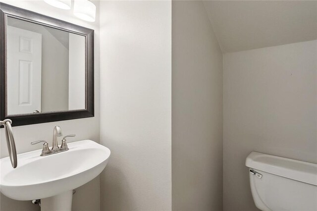 3604 Meadow Lake Dr W, Slidell, LA 70461 - bathroom with a sink, toilet, and lofted ceiling