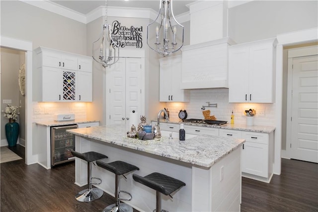 201 Jardin Loop, Covington, LA 70433 - kitchen featuring beverage cooler, stainless steel gas stovetop, white cabinetry, and ornamental molding