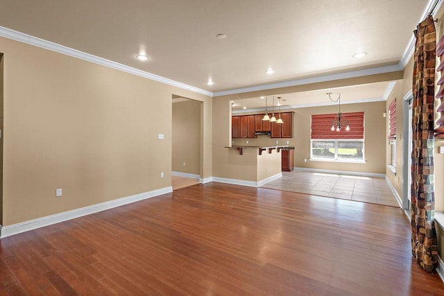 1134 Belair Blvd, Slidell, LA 70460 - unfurnished living room featuring a chandelier, ornamental molding, wood finished floors, baseboards, and recessed lighting