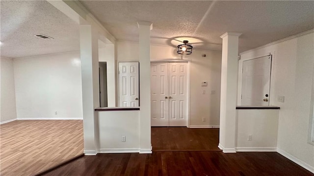spare room featuring a textured ceiling, wood finished floors, and baseboards