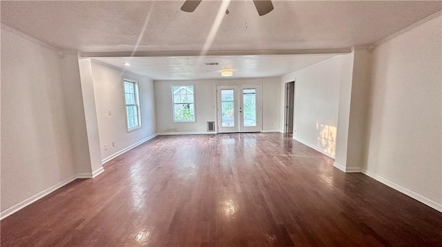spare room featuring wood finished floors, ornamental molding, a textured ceiling, ceiling fan, and baseboards
