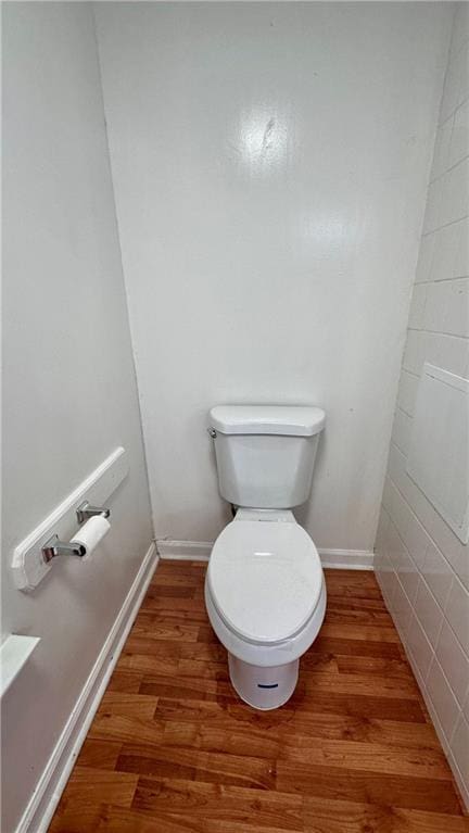 bathroom with wood finished floors, toilet, and baseboards