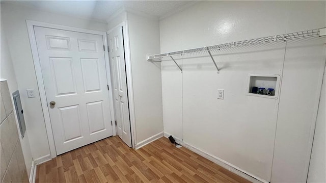 washroom featuring hookup for a washing machine, light wood-style flooring, and baseboards