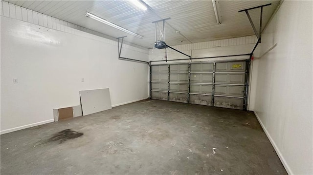 garage featuring a garage door opener and baseboards