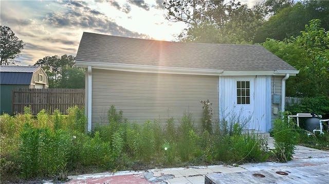 view of outbuilding with fence and an outbuilding