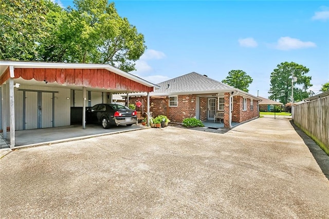 3117 Texas Ave, Kenner, LA 70065 - view of front of property with a carport, asphalt driveway, fence, brick siding, and a shingled roof