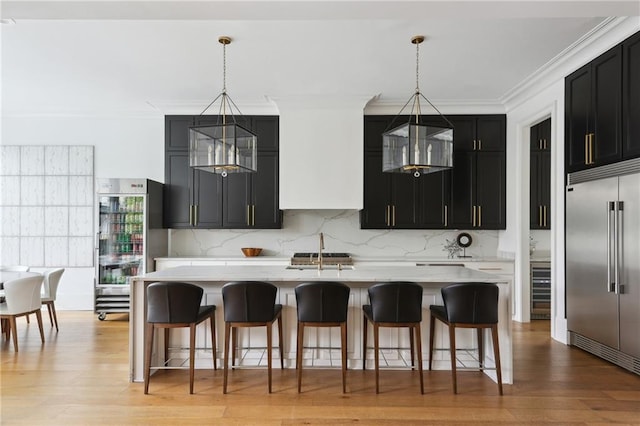 3804 Prytania St, New Orleans, LA 70115 - kitchen featuring stainless steel built in fridge, dark cabinets, light countertops, decorative backsplash, and crown molding