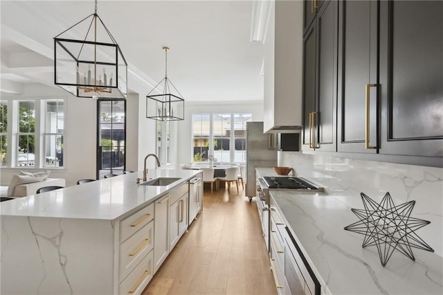 3804 Prytania St, New Orleans, LA 70115 - kitchen featuring a chandelier, a sink, plenty of natural light, and light stone counters