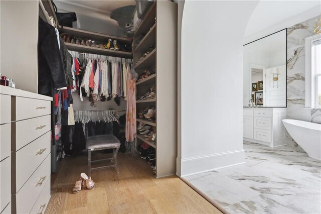 3804 Prytania St, New Orleans, LA 70115 - walk in closet with light wood-type flooring, a sink, and arched walkways