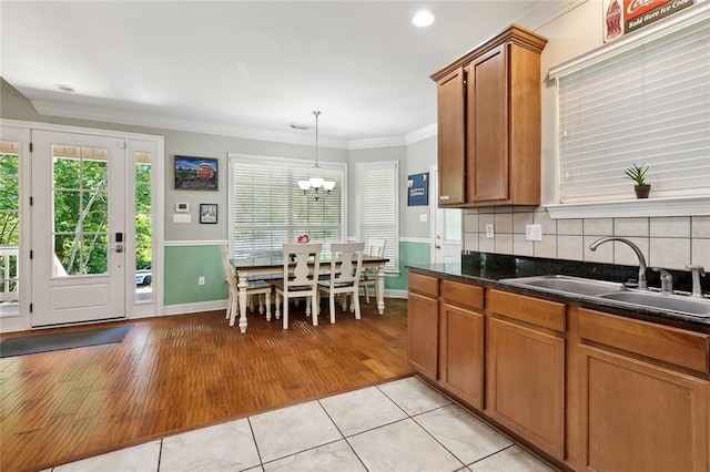 5 Rhonda Ct, Covington, LA 70433 - kitchen featuring a sink, brown cabinetry, ornamental molding, light tile patterned floors, and baseboards