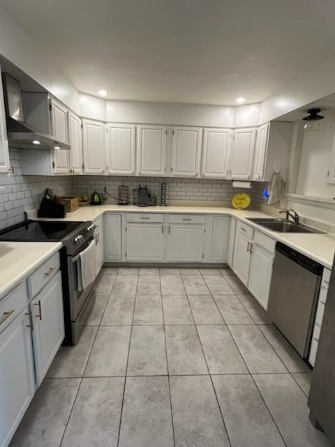 6133 Carlisle Ct, New Orleans, LA 70131 - kitchen with appliances with stainless steel finishes, a sink, backsplash, wall chimney exhaust hood, and recessed lighting