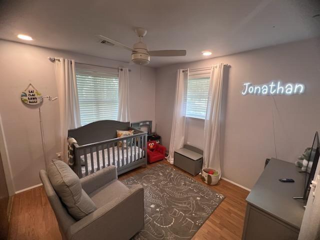 6133 Carlisle Ct, New Orleans, LA 70131 - bedroom featuring wood finished floors, baseboards, a ceiling fan, recessed lighting, and a crib