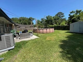 6133 Carlisle Ct, New Orleans, LA 70131 - fenced backyard featuring a storage unit and a patio area