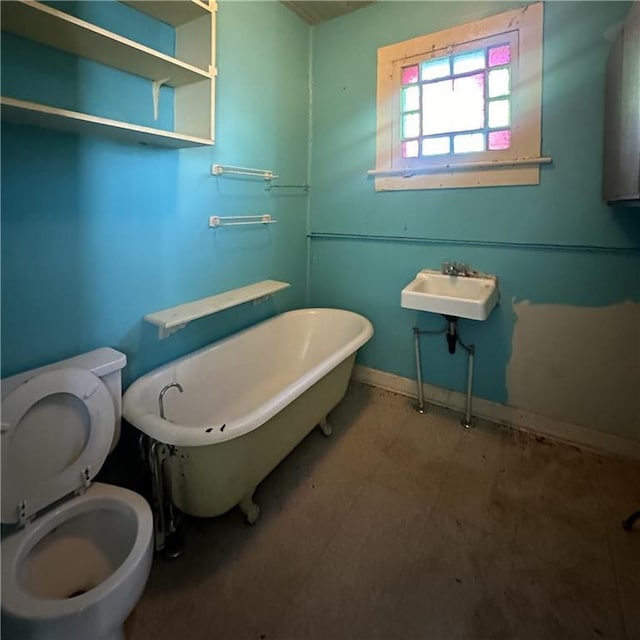 1919-1921 Bayou Rd, New Orleans, LA 70116 - full bathroom featuring toilet, a soaking tub, a sink, and baseboards