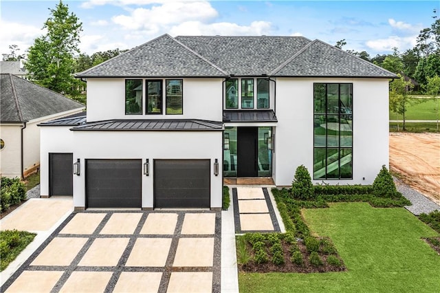 67 Hummingbird Rd, Covington, LA 70433 - view of front of home with a standing seam roof, an attached garage, concrete driveway, and stucco siding