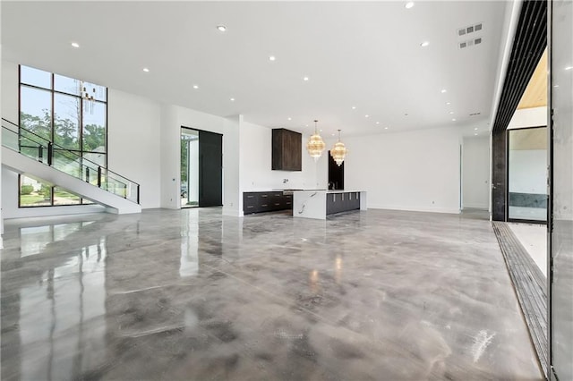 67 Hummingbird Rd, Covington, LA 70433 - unfurnished living room with concrete floors, stairs, and recessed lighting