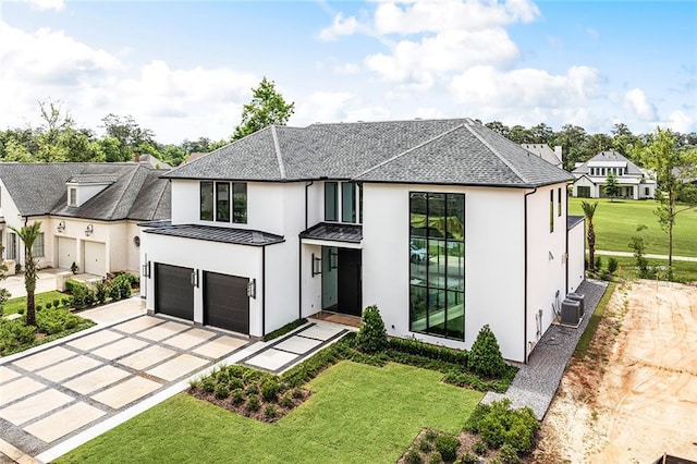 67 Hummingbird Rd, Covington, LA 70433 - view of front of house with stucco siding, an attached garage, a standing seam roof, driveway, and a front lawn
