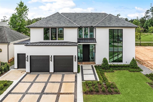 67 Hummingbird Rd, Covington, LA 70433 - view of front facade with stucco siding, a standing seam roof, concrete driveway, and a garage