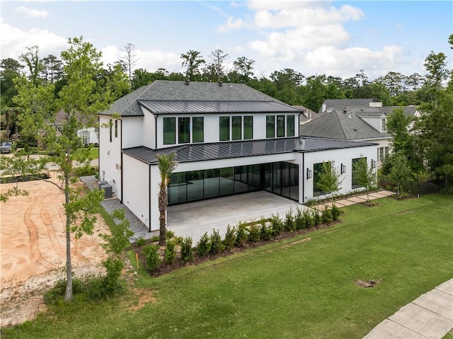 67 Hummingbird Rd, Covington, LA 70433 - rear view of house featuring a standing seam roof, metal roof, stucco siding, a yard, and a patio area