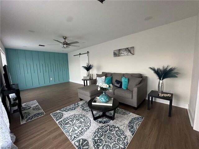 839 Behrman Ave, New Orleans, LA 70114 - living area featuring a barn door, a ceiling fan, wood finished floors, and baseboards