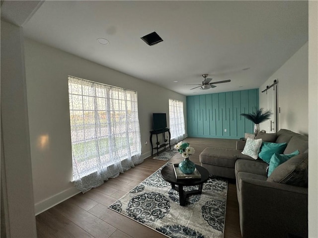 839 Behrman Ave, New Orleans, LA 70114 - living area featuring baseboards, wood finished floors, a ceiling fan, and a barn door