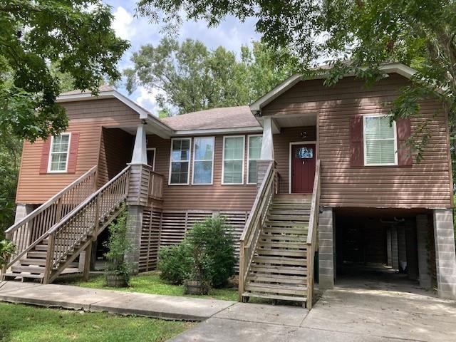 516-518 Erlanger Ave, Slidell, LA 70458 - view of front of house featuring stairway, concrete driveway, covered porch, and a garage
