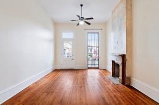 1700 S Rampart St, New Orleans, LA 70113 - unfurnished living room with a fireplace, baseboards, wood finished floors, and a ceiling fan