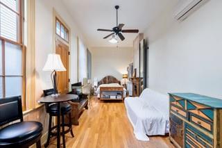 1700 S Rampart St, New Orleans, LA 70113 - bedroom featuring a wall mounted AC and wood finished floors