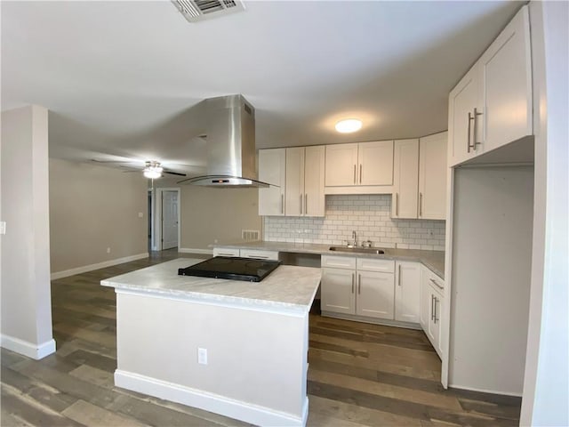 kitchen with island range hood, a sink, black electric cooktop, and white cabinets