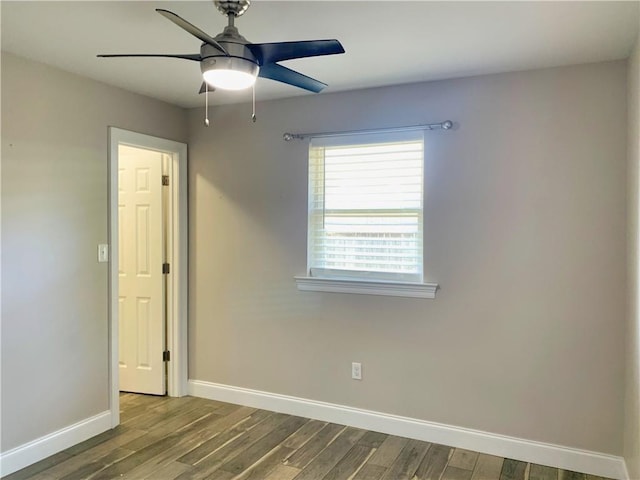 empty room featuring baseboards, wood finished floors, and a ceiling fan