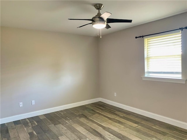 spare room with baseboards, ceiling fan, and dark wood-style flooring