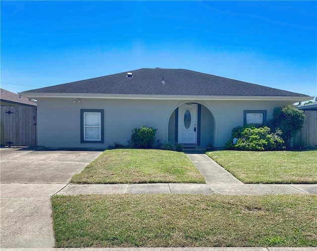 ranch-style house with stucco siding and a front lawn