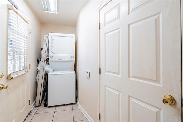 2315 Peniston St, New Orleans, LA 70115 - clothes washing area with stacked washing machine and dryer, light tile patterned floors, and baseboards
