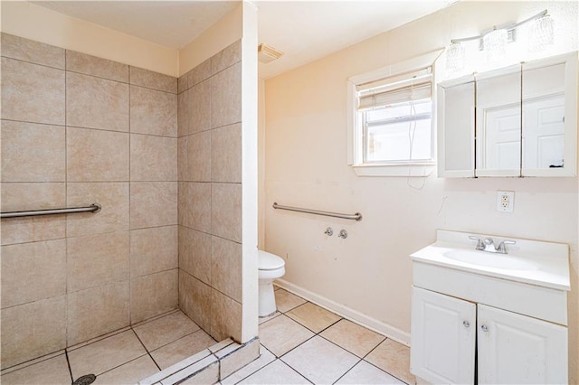 2315 Peniston St, New Orleans, LA 70115 - full bathroom with vanity, toilet, a tile shower, tile patterned floors, and baseboards