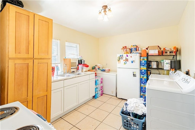 2315 Peniston St, New Orleans, LA 70115 - kitchen with freestanding refrigerator, a sink, light tile patterned floors, light countertops, and washer and dryer