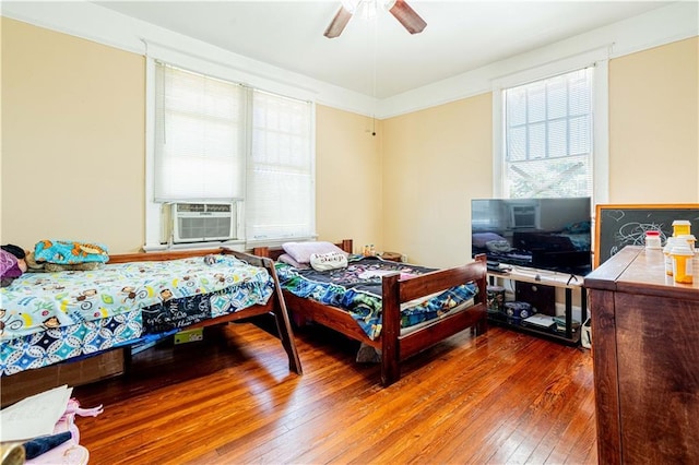 2315 Peniston St, New Orleans, LA 70115 - bedroom featuring wood-type flooring, multiple windows, cooling unit, and a ceiling fan