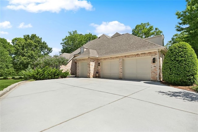474 Trailhead Dr, Abita Springs, LA 70420 - view of front of home featuring brick siding, a garage, concrete driveway, and roof with shingles