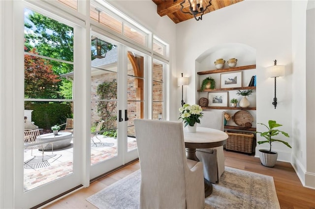 474 Trailhead Dr, Abita Springs, LA 70420 - doorway featuring plenty of natural light, light wood-type flooring, wood ceiling with exposed beams, a chandelier, and baseboards