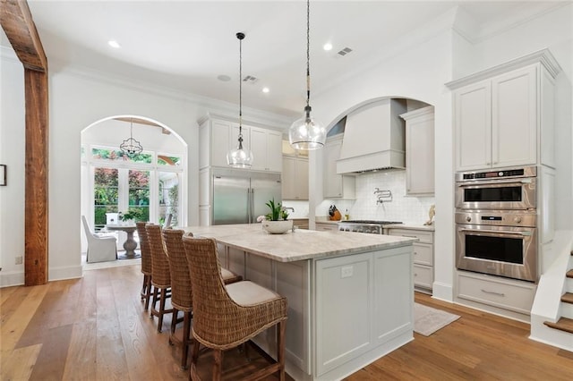 474 Trailhead Dr, Abita Springs, LA 70420 - kitchen with stainless steel appliances, arched walkways, decorative backsplash, ornamental molding, and light stone counters