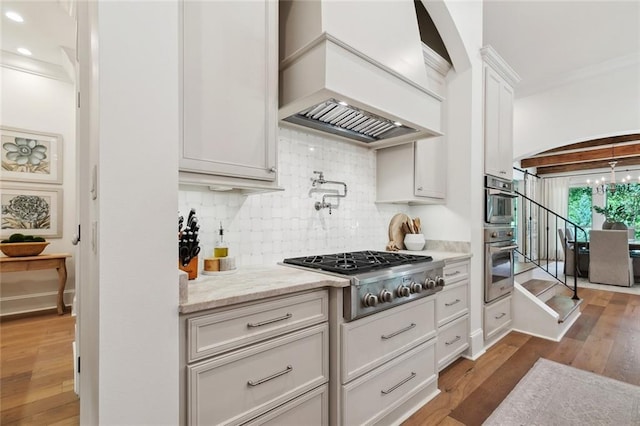 474 Trailhead Dr, Abita Springs, LA 70420 - kitchen featuring custom range hood, stainless steel appliances, backsplash, dark wood finished floors, and white cabinetry