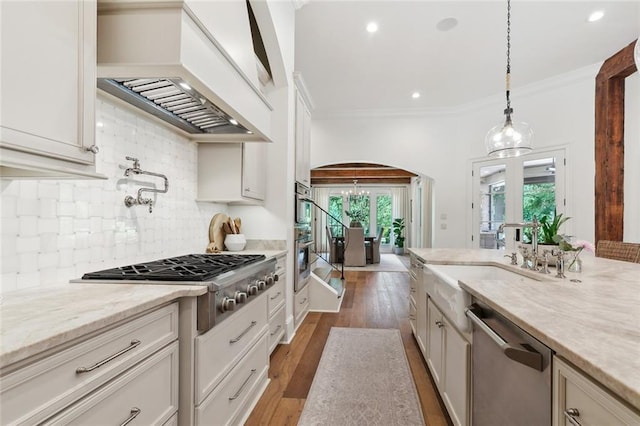 474 Trailhead Dr, Abita Springs, LA 70420 - kitchen with appliances with stainless steel finishes, premium range hood, arched walkways, a sink, and backsplash